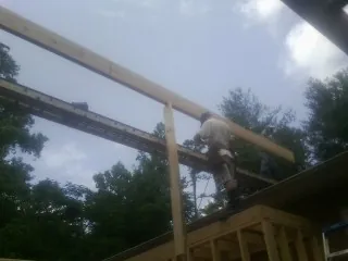 Carpenter setting a ridge beam over a new addition frame — Ice Dam Removal by Roofing Brothers in Cedar Park