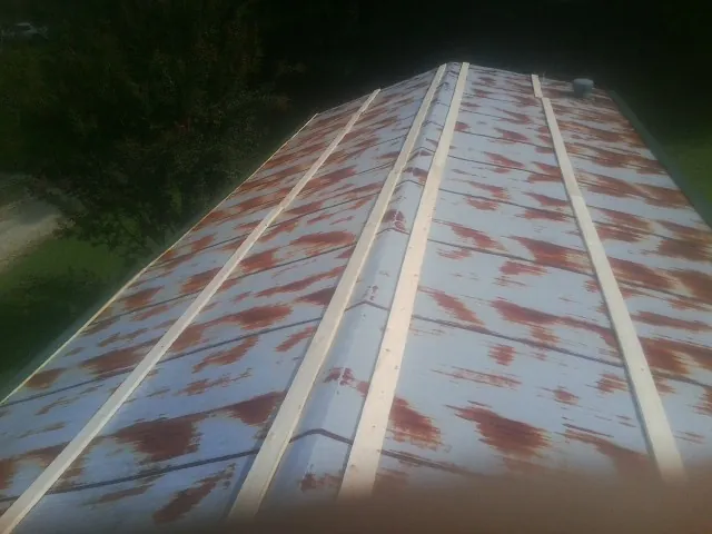 Rusted metal roof panels with new wood purlins before replacement — Storm Damage Roof Repair in Cedar Park by Roofing Brothers