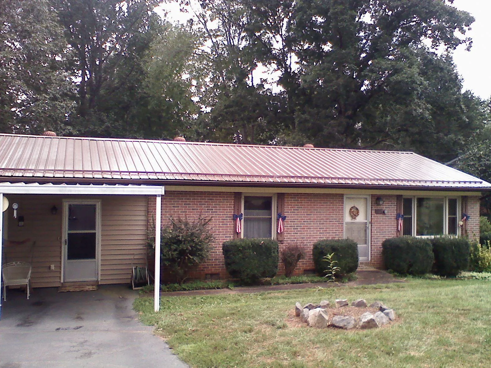 Bronze metal roof and carport on a brick ranch home — Roof Repair work by our crew in Cedar Park